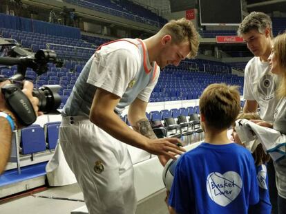 Doncic firma autógrafos a unos aficionados en el Wizink Center.