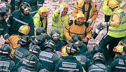 Bomberos del Ayuntamiento trasladan a uno de los heridos por el desplome de un edificio en la esquina de las calles de Gaztambide y Alberto Aguilera.