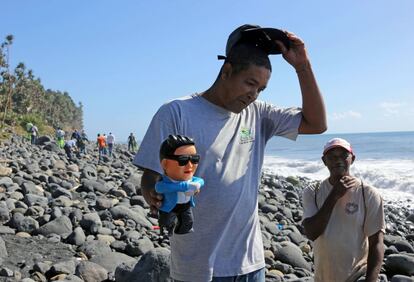 Un trabajador que participa en las labores de búsqueda de restos del vuelo MH 370 de Malaysia Airlines en una playa en Sinte-Marie de la Reunion, ha recuperado un muñeco del cantante surcoreano Psy.