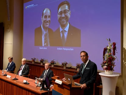 Thomas Perlmann, secretario de los Nobel (en el atril), anuncia los premiados en Medicina, en la pantalla: David Julius (izquierda) y Ardem Patapoutian.