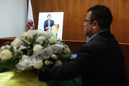 Un hombre coloca una corona de flores sobre uno de los ataúdes, este martes durante el homenaje.