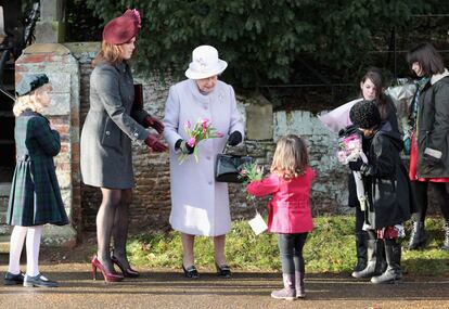 ... aunque la verdadera protagonista fue la reina Isabel II, que asistió a la misa por primera vez sin la compañía de su marido, el duque de Edimburgo, que se encuentra ingresado en el Hospital Papworth tras ser operado de una arteria del corazón. En la foto, la soberana recibe flores de los niños presentes junto a su nieta, la princesa Eugenia.