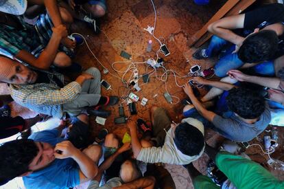 Un grupo de refugiados cargan sus teléfonos móviles en la estación de tren del Este en Budapest, Hungría.