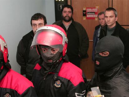 La Ertzaintza precinta la sede de Batasuna en San Sebastián. Detrás de los agentes de la policía autonómica, Juan José Petrikorena, Joseba Albarez, Jon Gorrotxategi y Joseba Permach.
