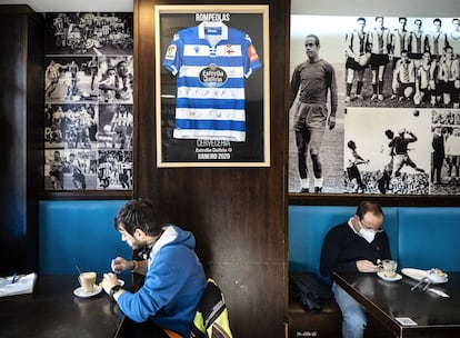 El bar Rompeolas tiene en la pared fotos de ídolos históricos del club. A la izquierda de la camiseta enmarcada vemos a Luis Suárez, coruñés y único español balón de Oro (en 1965 con el Inter de Milán), y a la derecha, imágenes de la época dorada de los años noventa y dos mil: por ejemplo, la del atleta de Cristo Donato levantándose la camiseta tras marcar el gol del partido en el que el Dépor se proclamó campeón de Liga.