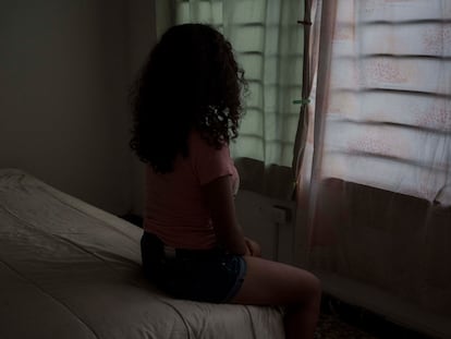 Catalina, de 16 años, mira por la ventana de una casa que no es la suya en Cartagena de Indias, Colombia.