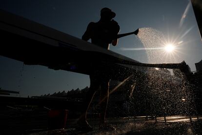 Un atleta de Nueva Zelanda enjuaga un bote antes de las competencias de remo, en Vaires-sur-Marne, este lunes.