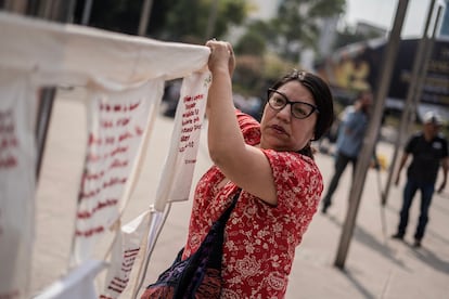 Regina Méndez, una activista del colectivo 'Fuetes rojas' coloca uno de los tendederos donde bordan los casos de desapariciones. 