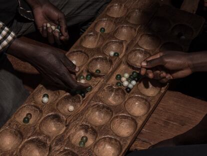 Dos hombres juegan al bao, un juego de mesa tradicional de la familia del mancala, en Naycuanga, un pueblo agrícola del distrito de Lago. El bao es muy popular entre los suajili de África oriental.