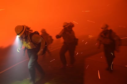 Bomberos se alejan de las llamas, avivadas por el viento, durante el incendio Franklin, en Malibú (California), a principios de este diciembre.