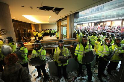 Policías antidisturbios custodian al recepción de la torre Millbank, donde se encuentra la sede del Partido Conservador británico.