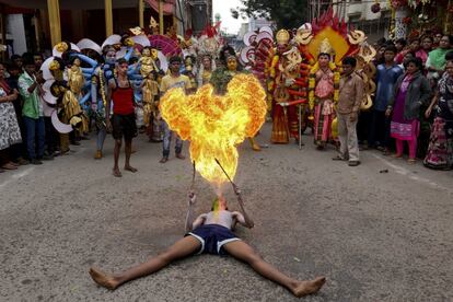 Un artista indio realiza un espectáculo con fuego durante la procesión del festival 'Bonalu', en Hyderabad (India).