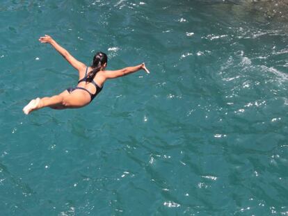 Una chica salta en Acapulco durante la celebraci&oacute;n de una tradici&oacute;n que es atractivo tur&iacute;stico en la costa mexicana.