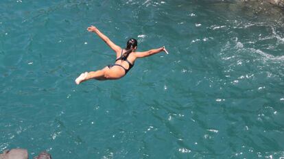 Una chica salta en Acapulco durante la celebraci&oacute;n de una tradici&oacute;n que es atractivo tur&iacute;stico en la costa mexicana.