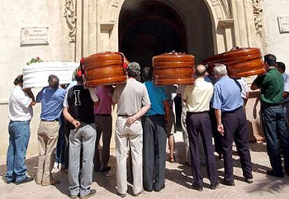 Los féretros con los restos mortales de las víctimas del incendio son llevados a la iglesia de Lorca para el funeral.