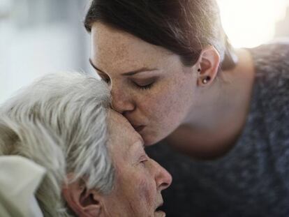 Una mujer besa a su madre en un hospital.