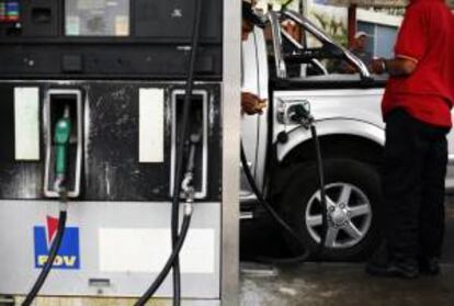 Un par de hombres trabajan en una estación de servicio de gasolina. EFE/Archivo