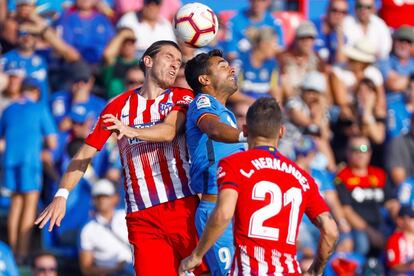 El delantero del Getafe Angel Luis Rodríguez pelea un balón con el defensa brasileño del Atlético de Madrid Filipe Luis.