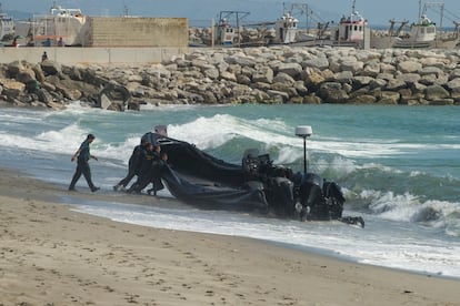 Agentes de la Guardia Civil arrastran una lancha abandonada por los narcos tras una persecución, en la playa del Tonelero, en La Atunara (Cádiz).
