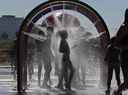 Niños juegan con agua en un parque de Buenos Aires para hacer frente a la ola de calor.