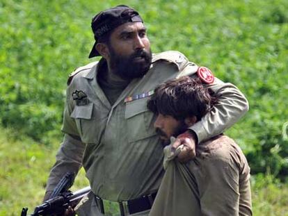 Un paramilitar detiene a uno de los asaltantes en Lahore.