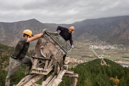 Hoy en día, cientos de habitantes de Bulqizë trabajan en las minas con explosivos, equipamiento y sistemas de transporte del material que datan de la década de 1950, arriesgando su vida a diario. Cada minero extrae una media de ocho toneladas de cromita por cada jornada de trabajo, equivalente a un ingreso diario aproximado de 1.600 dólares, a cambio de un salario mensual de 350 dólares. En los últimos años se han producido varios accidentes y muchos mineros han perdido la vida por falta de medidas de seguridad en el trabajo. En la imagen, dos mineros descargan mena de cromita de una vieja vagoneta en la cima de la montaña.