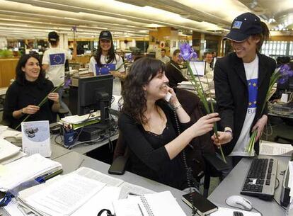 Dos periodistas de EL PAÍS reciben una flor con motivo del Día de la Mujer Trabajadora.