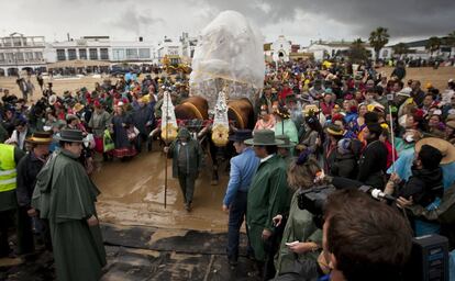 La hermandad rociera de Sanlúcar tuvo que proteger la imagen de la virgen con plásticos para evitar que la lluvia la estropeara.