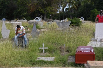 Un hombre en un cementerio donde fue enterrada una víctima del naufragio en Trinidad y Tobago.