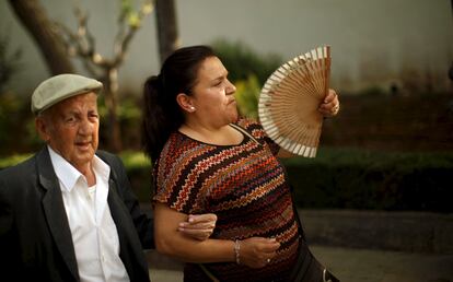 Una mujer utiliza un abanico para protegerse de las altas temperaturas en una calle de Ronda (Málaga).