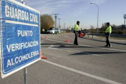 Dos agentes de la Dirección General de Tráfico, se preparan para realizar un control de la tasa de alcohol. EFE/Archivo