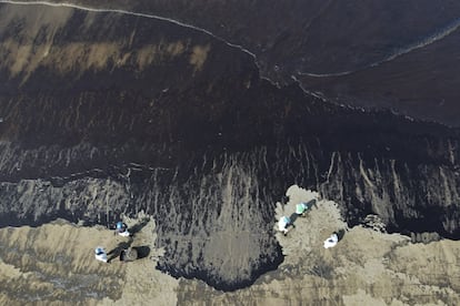 Imagen aérea de los trabajos de limpieza en la playa Cavero, en la provincia de Callao, en Perú, este martes. El vertido se produjo el sábado en una terminal de la refinería La Pampilla, operada por Repsol, horas después de la erupción de un volcán submarino en Tonga.