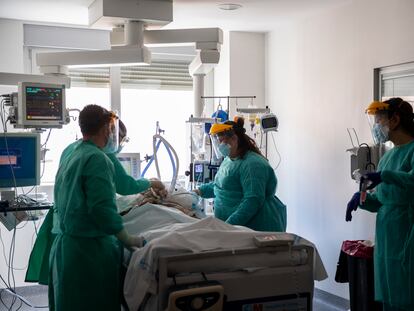 Varios sanitarios atienden a un paciente infectado de covid-19 en la UCI del hospital de Torrejón de Ardoz, este martes.