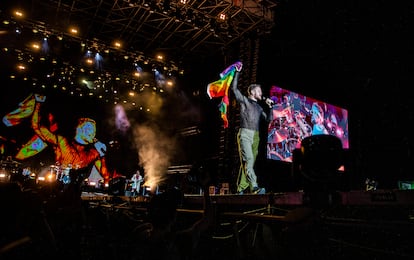 Dan Reynolds, líder de Imagine Dragons, con una bandera arcoíris que le lazaron desde el público.