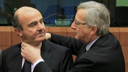 Juncker aprieta el cuello, en un gesto amistoso a Luis de Guindos.