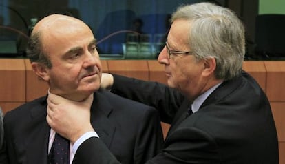 Juncker aprieta el cuello, en un gesto amistoso a Luis de Guindos.