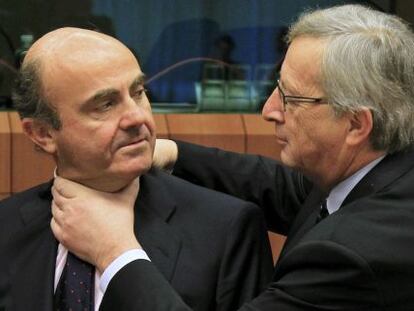 Juncker aprieta el cuello, en un gesto amistoso a Luis de Guindos.