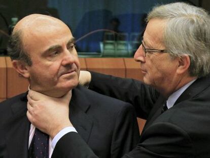 Juncker aprieta el cuello, en un gesto amistoso a Luis de Guindos.