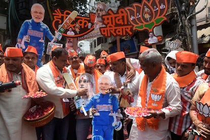 Simpatizantes del Partido Popular Indio esperan los resultados de las elecciones portando un figura de cartón de Modi, este martes en Benarés (India).    