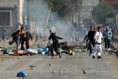 Un grupo de jóvenes tira piedras durante los enfrentamientos con la policía en un barrio de Orán, en Argelia.