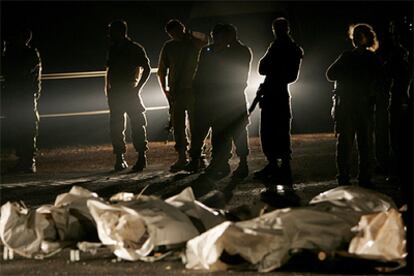 Un grupo de soldados israelíes monta guardia ante varios cadáveres en Yiron, en el norte de Israel.