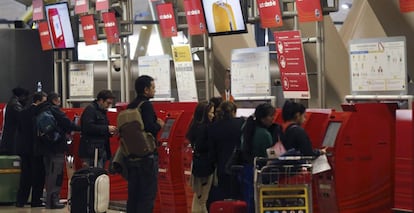 Varias personas guardan cola junto a los mostradores de facturación de la Terminal T4 del aeropuerto de Madrid-Barajas.