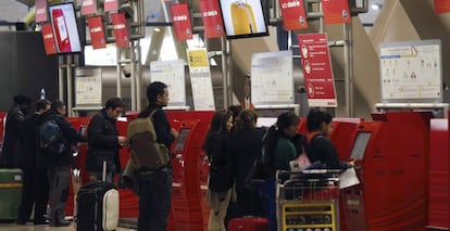 Varias personas guardan cola junto a los mostradores de facturación de la Terminal T4 del aeropuerto de Madrid-Barajas. 