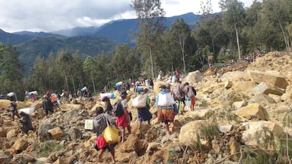 A group of people move among the rocks this Sunday after the landslide that affected northern Papua New Guinea.