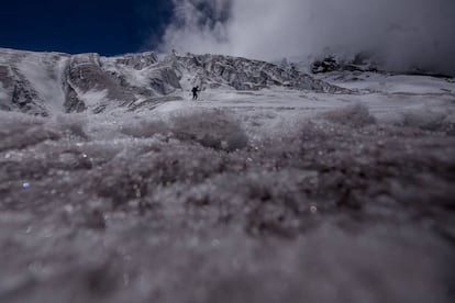 Un hombre camina sobre un glaciar en el volcán Antisana, a 50 kilómetros al este de Quito, Ecuador.