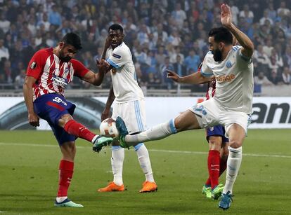 Diego Costa de Atlético disputa el balón con Adil Ramh de Olympique.