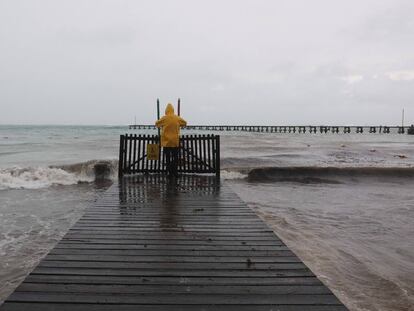 Un hombre toma fotos al mar durante el paso del Huracán Delta en Cancún.