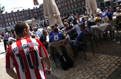 Bart Simpson y Mickey Mouse, con camisetas del Chelsea, y Homer Simpson y Minnie Mouse, del Atlético de Madrid, han sido los encargados de ir calentando motores en la Puerta del Sol, para motivar a aficionados de ambos equipos y subir la temperatura del duelo futbolístico de esta noche. En la imagen, aficionados de ambos equipos en la Plaza Mayor.