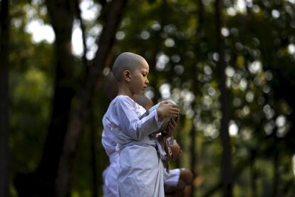 Novice nuns stand in line before receiving food from people during the Songkran Festival at the Sathira-Dhammasathan Buddhist meditation centre in Bangkok, Thailand, April 13, 2016. REUTERS/Athit Perawongmetha