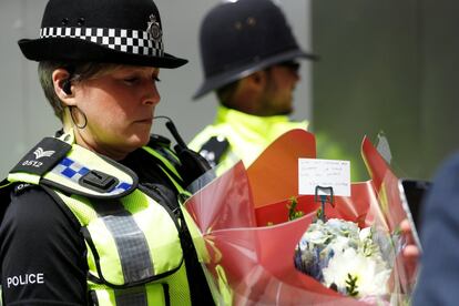 Una agente de policía lleva un ramo de flores en recuerdo a las víctimas del atentado terrorista cerca de Borough Market.